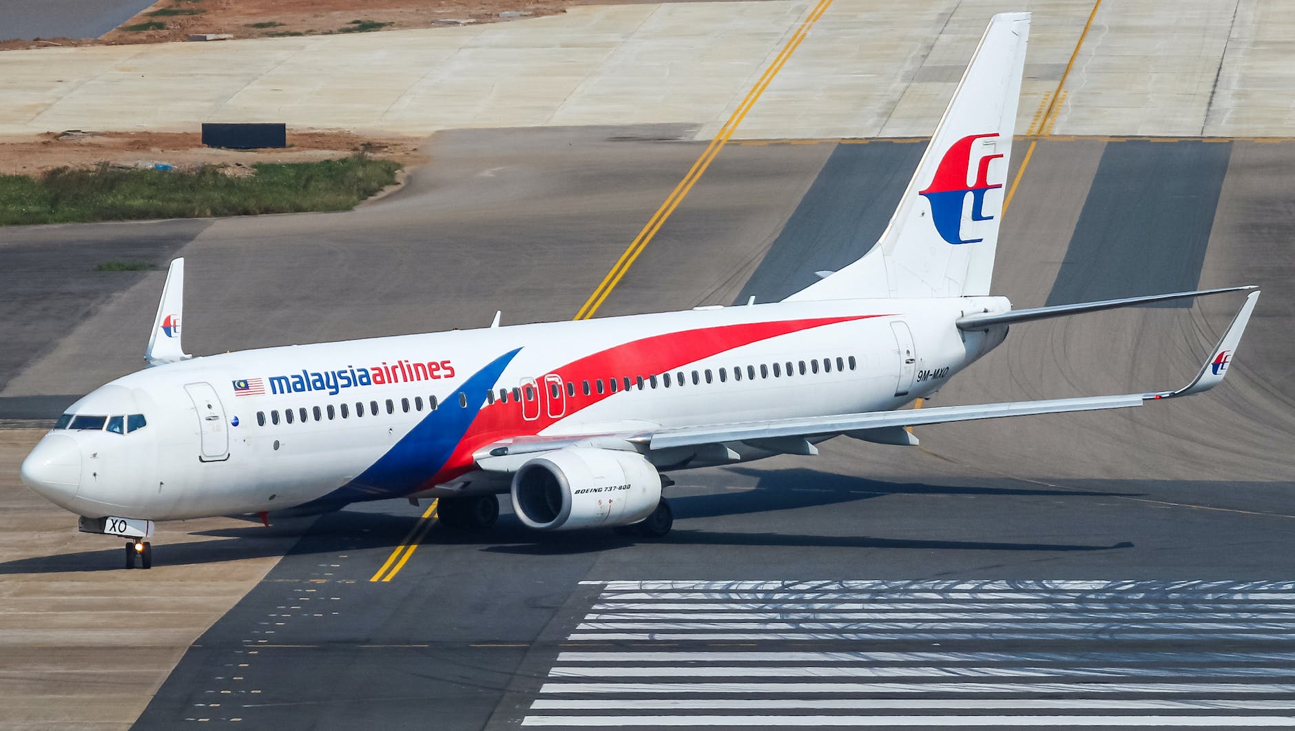 a malaysia airlines airplane taxiing on runway
